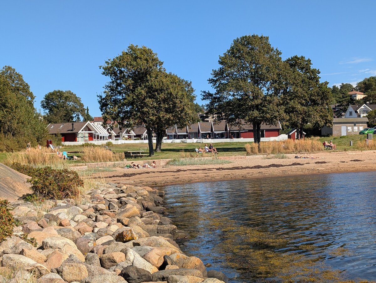 Badende ved Rekkeviksbukta med fasiliteter i bakgrunnen